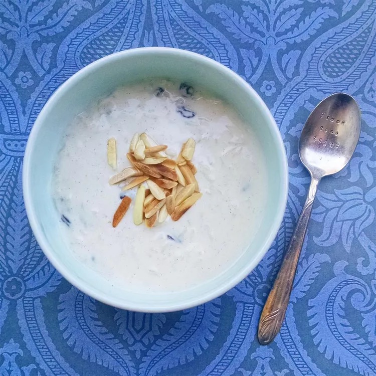 Rice pudding in bowl topped with chapped nuts